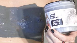 Slender brunette applies liquid latex on her body