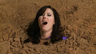 Big-boobed super-girl in latex suit is getting buried alive