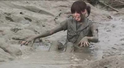 Dirty Japanese doll falls on grey dirt without getting naked