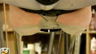 Latex-suited busty whore is tortured in an complex bondage device